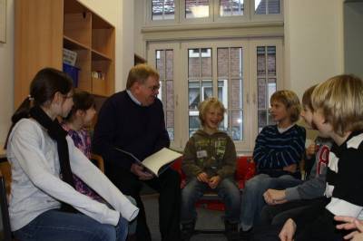 Reinhold Sendker MdB liest einer Gruppe aus Dritt- und Viertklsslern aus dem Buch Die zertanzten Schuhe vor.